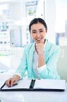 Smiling businesswoman with notes at desk