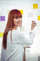 Attractive hipster woman writing on sticky notes