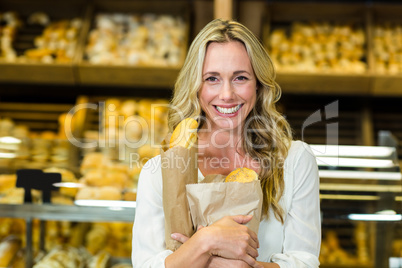 Beautiful woman holding paper bag with bread