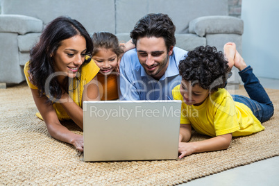 Smiling family using laptop in living room