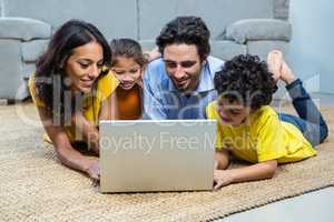 Smiling family using laptop in living room