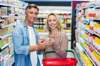 Smiling couple holding canned food