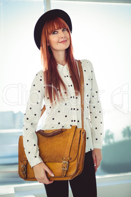 Portrait of a smiling hipster woman with a bag