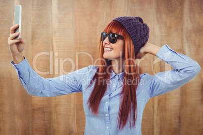 Smiling hipster woman taking selfie