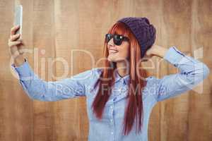 Smiling hipster woman taking selfie