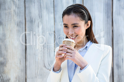 Smiling businesswoman with take-away coffee