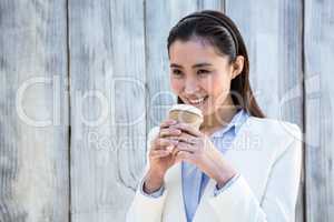 Smiling businesswoman with take-away coffee