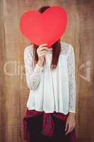 Smiling hipster woman behind a big red heart
