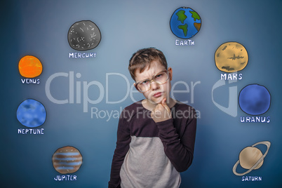 Teenage boy in glasses thinking planets of the solar system astr