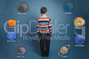 Teenage boy standing with his back planets of the solar system a