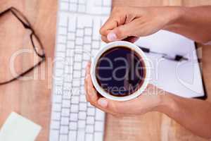 Businesswoman holding black coffee cup