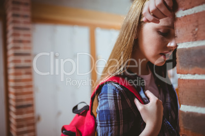 Worried student leaning against the wall