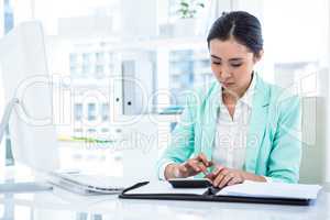 Smiling businesswoman with notes at desk