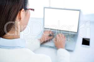 Rear view of businesswoman using laptop