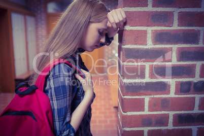 Worried student leaning against the wall