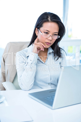 Serious businesswoman using laptop