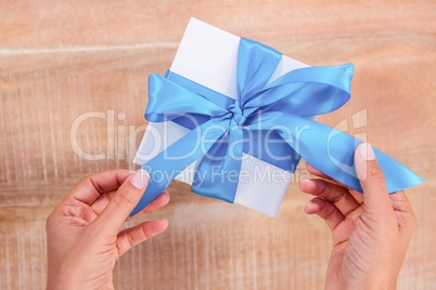 Woman presenting gift with blue ribbon