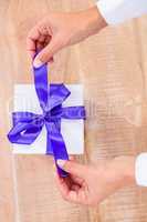 Woman presenting gift with purple ribbon