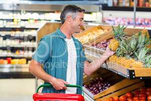 Smiling man choosing pineapple