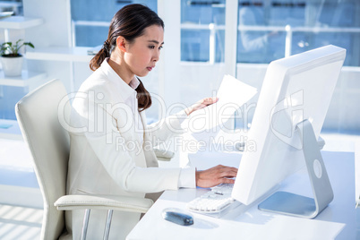 Smiling businesswoman reading work documents