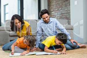 Family sitting on carpet in living room
