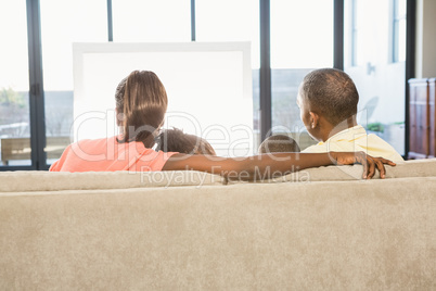 Over shoulder view of casual family watching tv