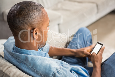 Over shoulder view of casual man using smartphone