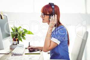 Attractive hipster woman with headset using graphics tablet
