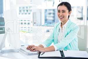 Smiling businesswoman with notes at desk