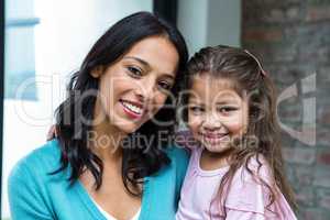 Smiling mother and daughter in living room