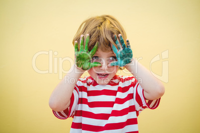 Boy holding his paint covered hands up