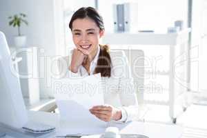 Smiling businesswoman reading work documents