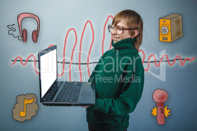 Teenage boy in green sweater and glasses holds a laptop and laug