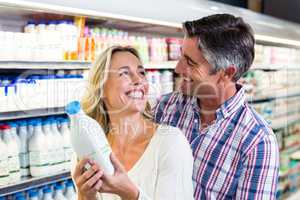 Smiling couple holding milk