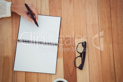 Cropped image of woman writing on notepad