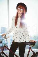 Smiling hipster woman with her bicycle