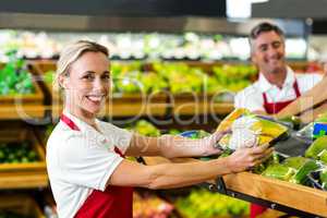 Smiling woman filling vegetables boxes