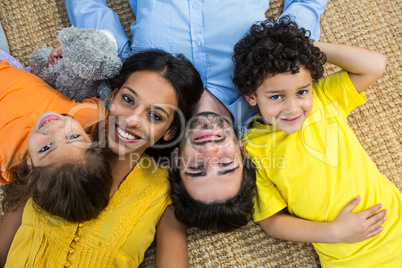 Smiling family laying on carpet