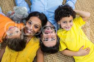 Smiling family laying on carpet