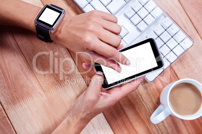 Feminine hands with smartwatch using smartphone