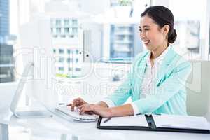 Smiling businesswoman with notes at desk