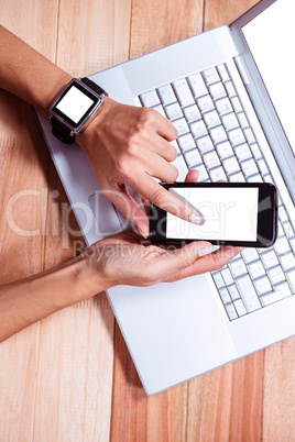 Woman with smartwatch using smartphone
