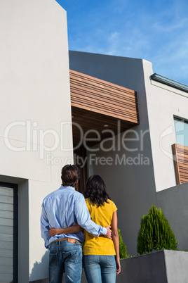 Happy couple standing and looking at the new house