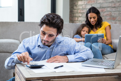 Serious man paying bills in living room