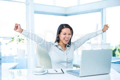 Happy businesswoman with raised arms
