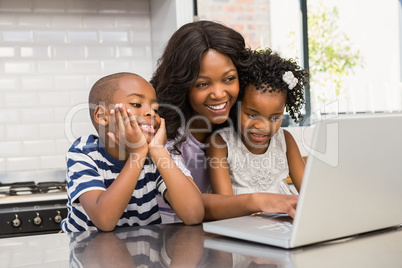 Mother and children using laptop