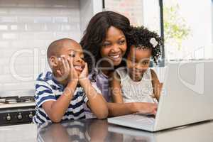 Mother and children using laptop