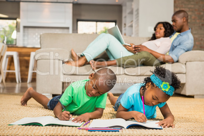 Happy siblings on the floor drawing