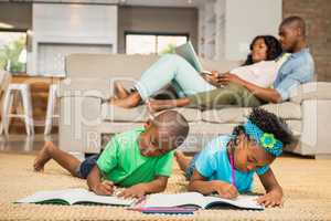 Happy siblings on the floor drawing