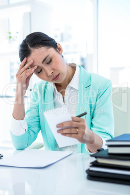 Stressed businesswoman sitting with notes